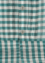 Close-up of the HaaT 2 SIDE PINTUCKING shirt—green, white, and gray plaid with vertical pintucks and three light buttons. Cotton silk fabric texture and detailed stitching are clearly visible.