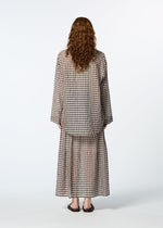 A person with long curly hair models HaaT's 2 SIDE PINTUCKING brown and beige gingham cotton-silk blend long-sleeve shirt and matching skirt, standing with their back to the camera against a white background.