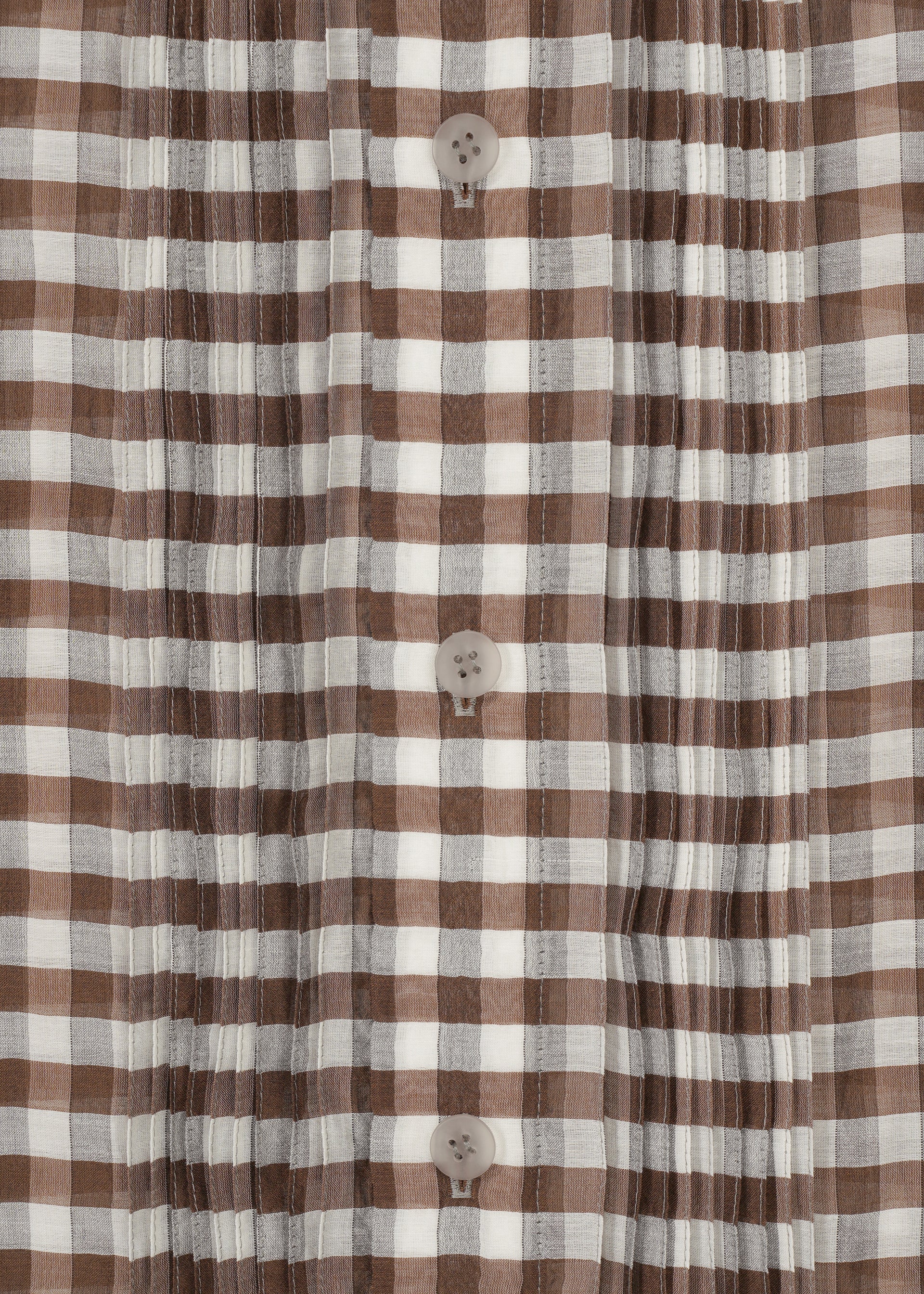 Zoomed view Close-up of the HaaT 2 SIDE PINTUCKING shirt, featuring brown and white gingham checks, vertical pintucks, and four beige center buttons.