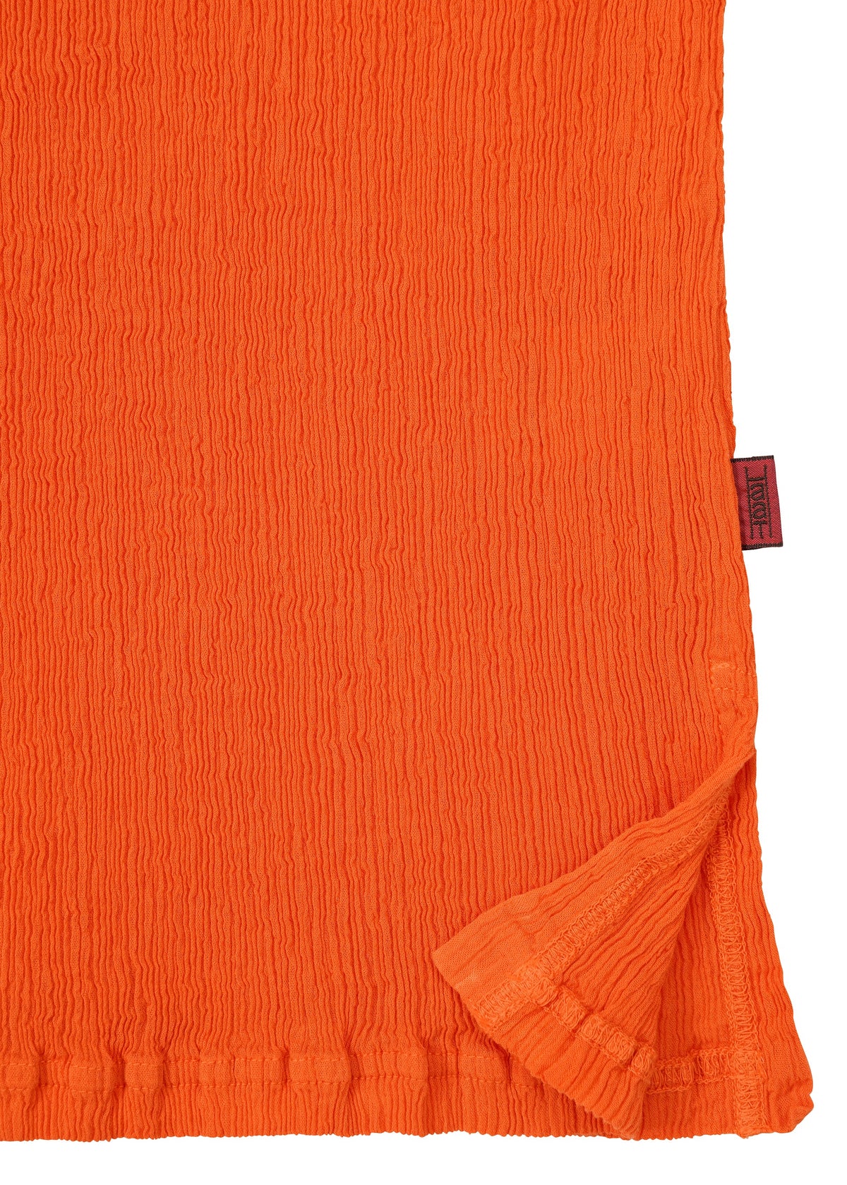A close-up of the textured orange fabric from the HaaT KYO CHIJIMI MAY top, highlighting its ultra-fine cotton weave, slightly crinkled surface, a folded corner, and a small red tag on the edge. view 5 of 8