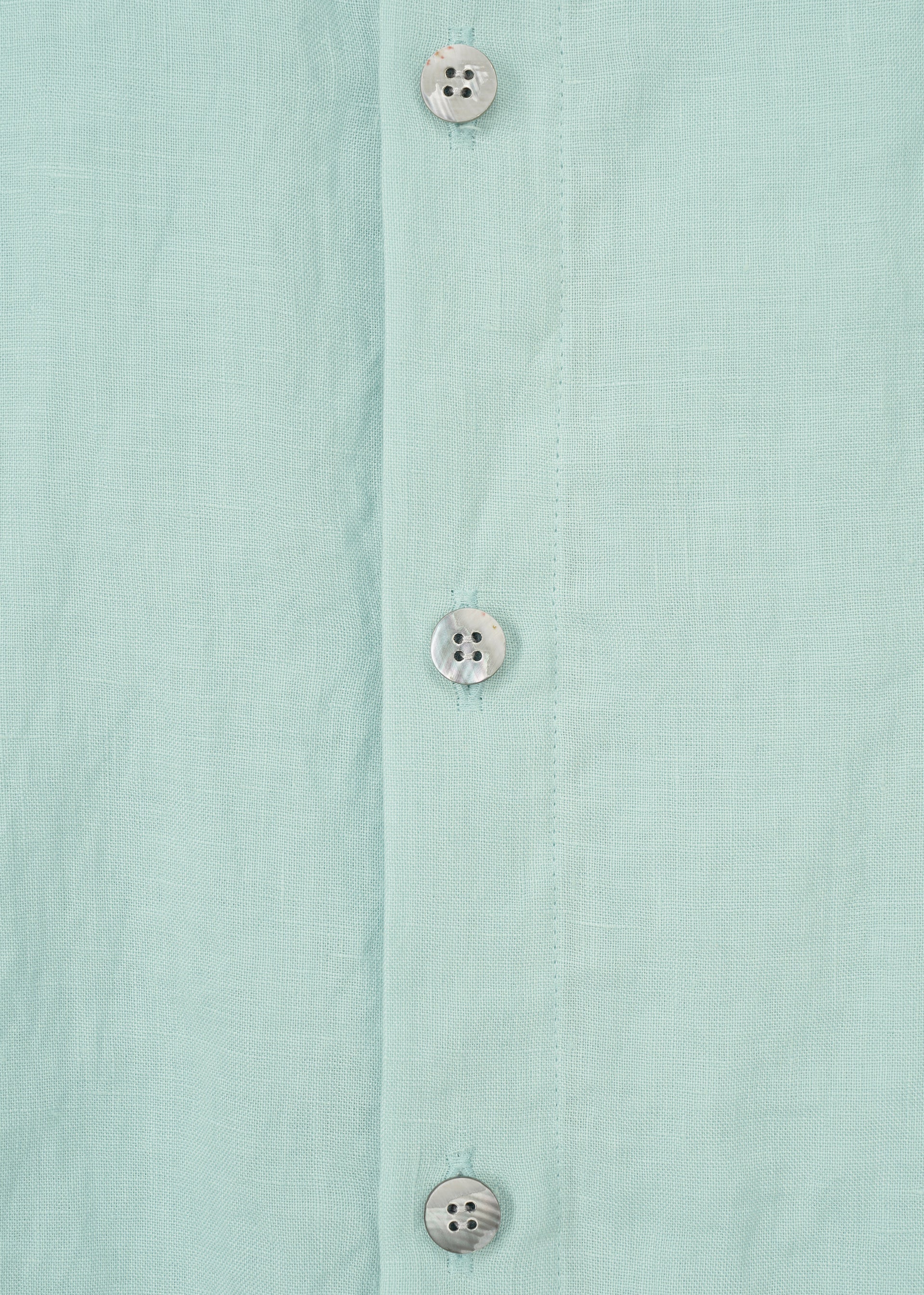 Zoomed view Close-up of the JIKI blouse by HaaT: a light blue women's top made from French linen, featuring three white plastic buttons on the vertical placket.