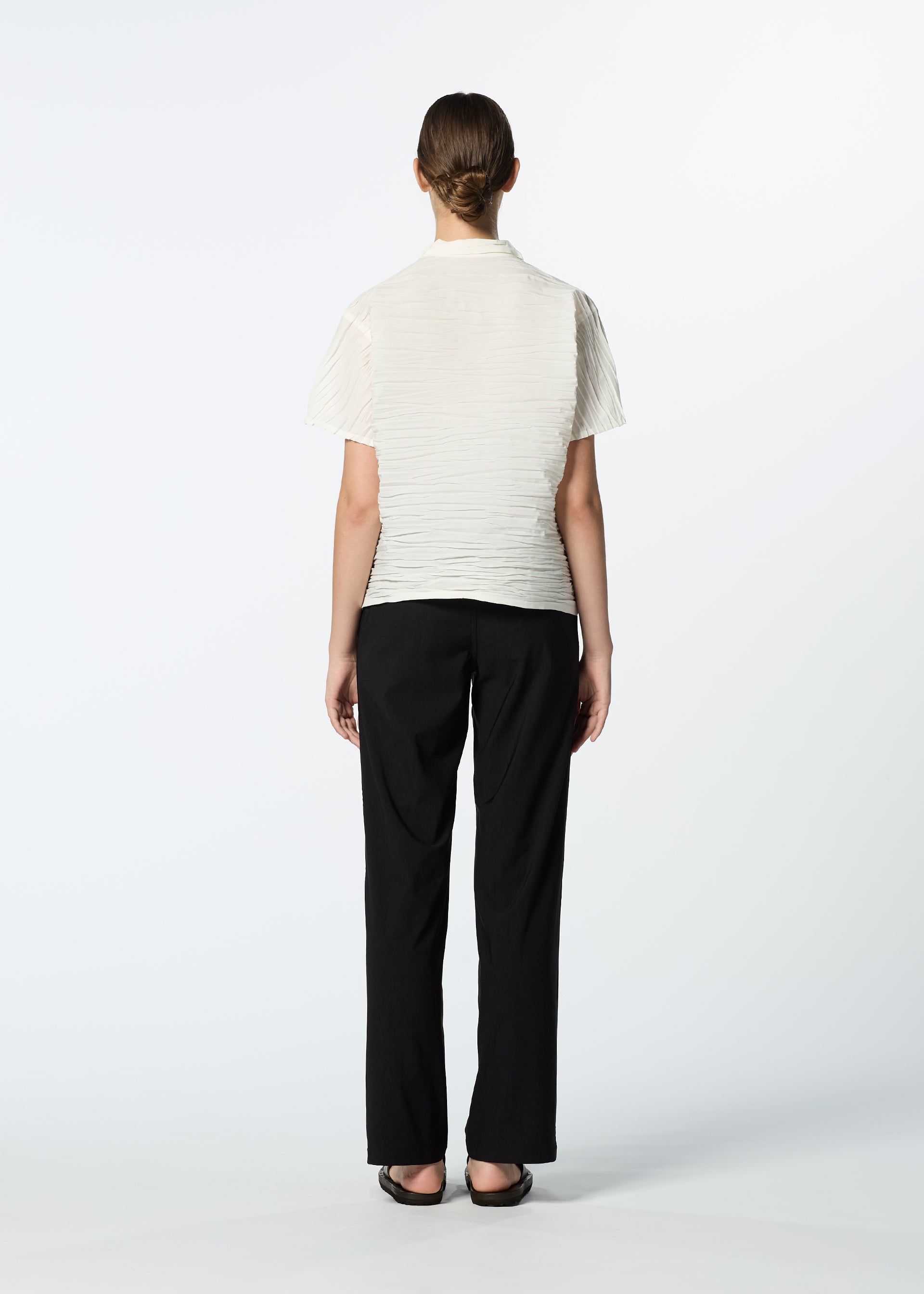 Zoomed view A person faces away from the camera wearing HaaT's SHIBARI SHIRT, paired with black trousers and shoes, set against a plain white background.