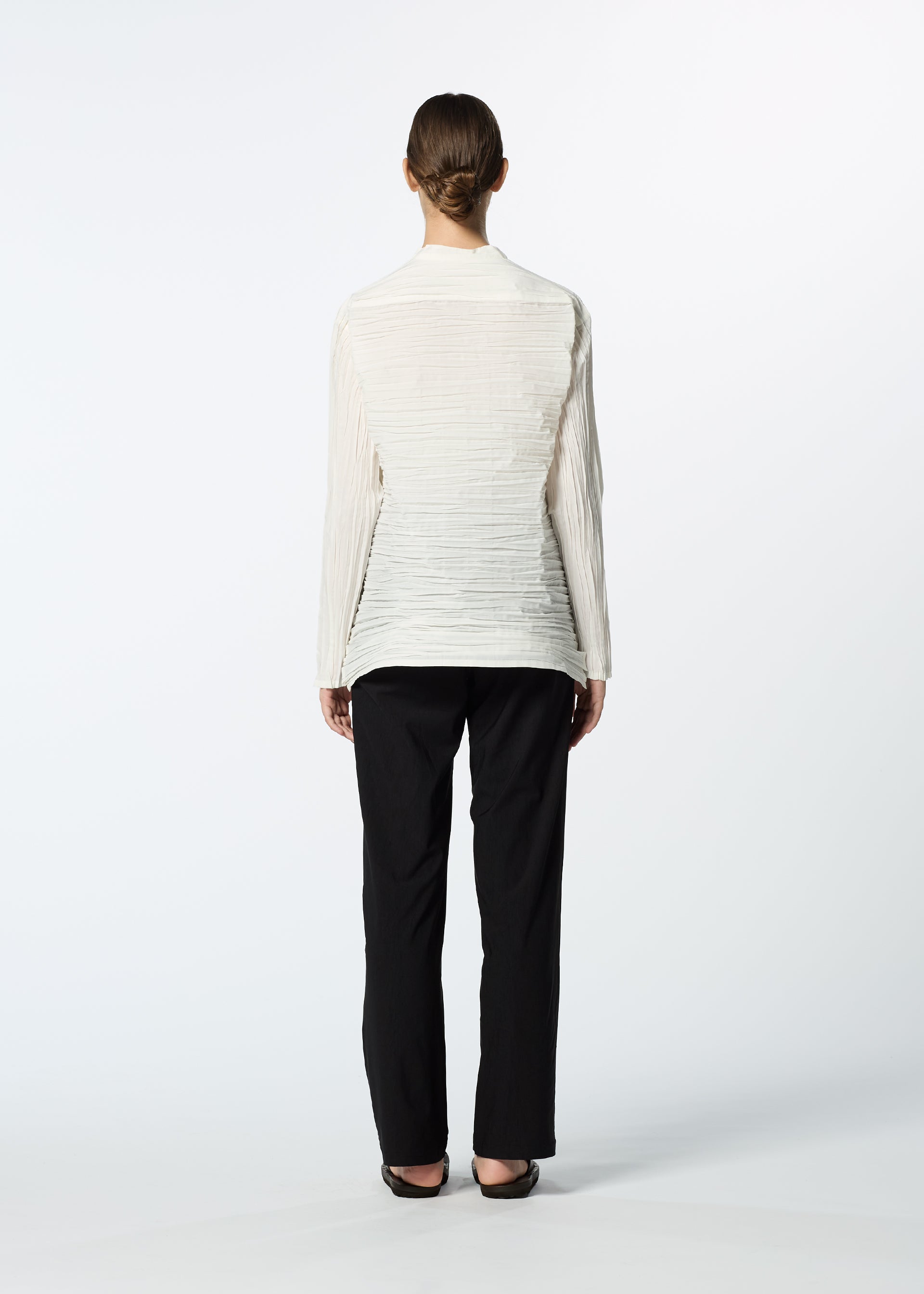 Zoomed view A person faces away from the camera, wearing the HaaT SHIBARI SHIRT with long sleeves, black straight-leg pants, and black shoes against a plain white background.