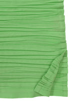Close-up of HaaT's SHIBARI SHIRT in green recycled polyester, showing horizontal pleats. A fold at the bottom right is slightly lifted, revealing the layered detail typical of this long-sleeved design.