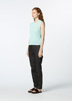 A person with long, wavy red hair models the HaaT KYO CHIJIMI TOBIKANNA CADEAU sleeveless top in light blue, paired with dark straight-leg pants and black sandals, standing against a plain white background.