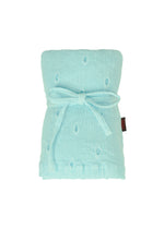 The HaaT KYO CHIJIMI TOBIKANNA CADEAU is a light blue textured blanket featuring a raised dot pattern, inspired by Tobikanna embroidery, neatly folded and tied with a matching fabric bow against a white background.