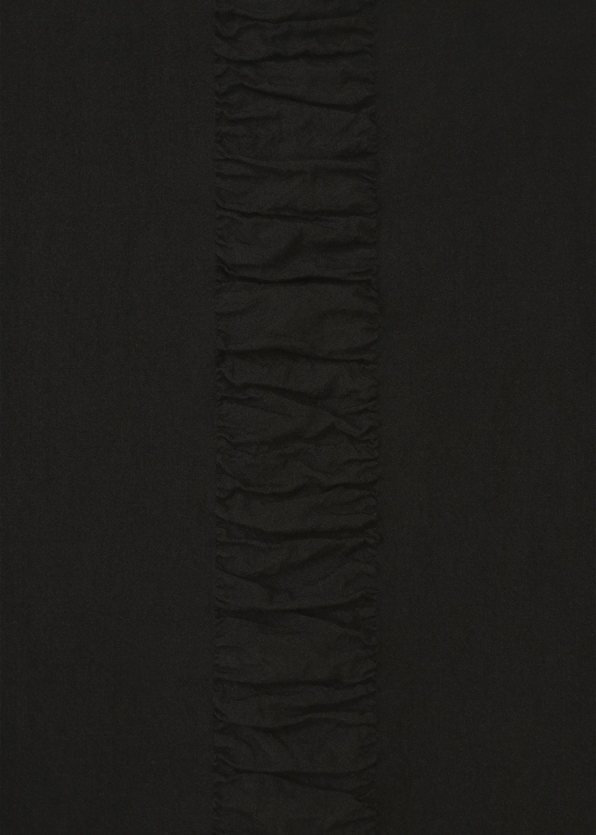 A close-up of HaaT's TENMOKU COTTON shows black, garment-dyed long-sleeve fabric with a vertical ruched strip down the center, creating textured contrast against the smoother fabric on each side. view 3 of 7
