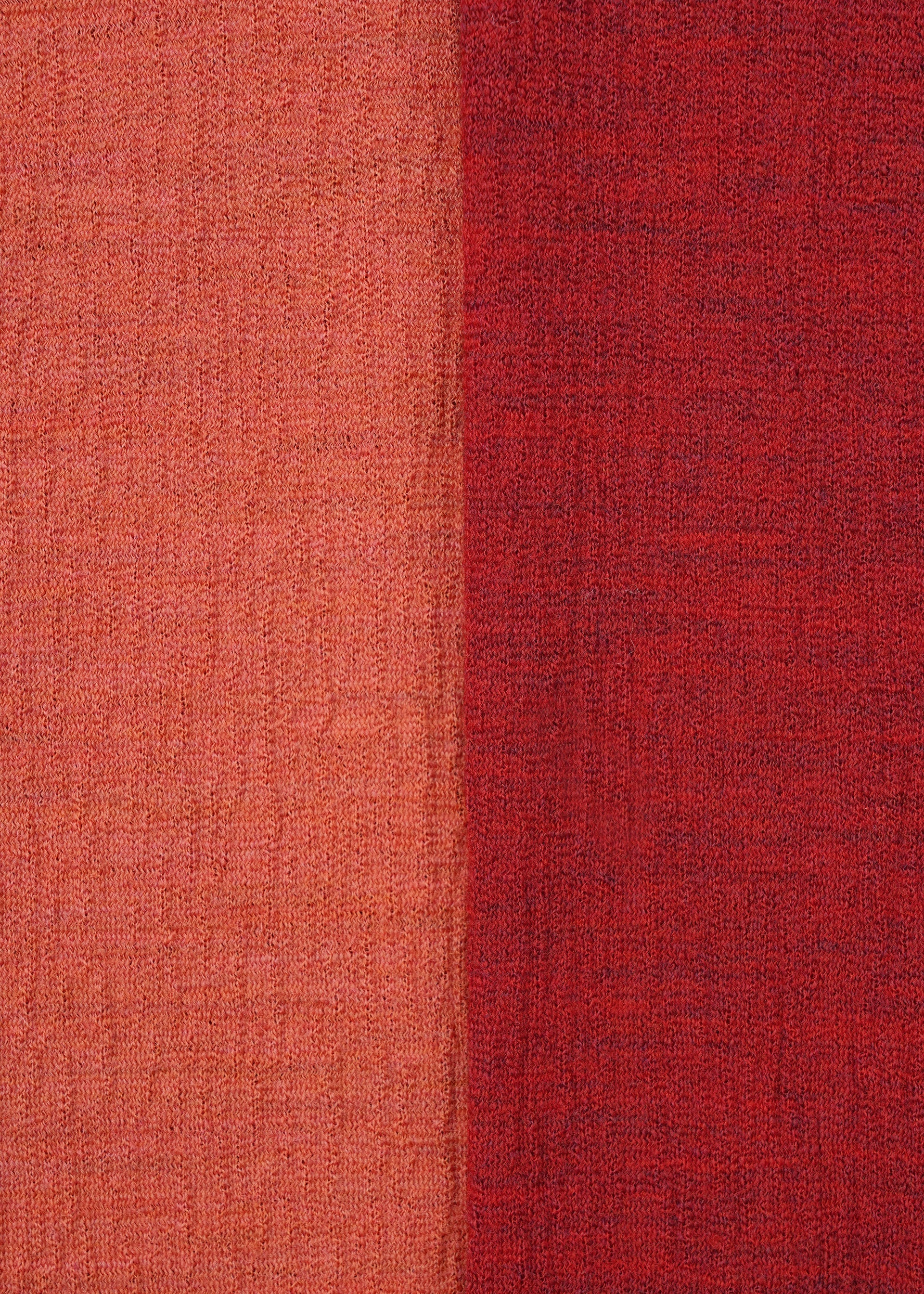 Zoomed view Close-up of HaaT's TRI COLOR WOOL fabric: vertically split with light orange-red on the left, deeper red on the right. Both textured sides have a woven, slightly rough look—ideal for relaxed merino wool or multicolor jersey pants.