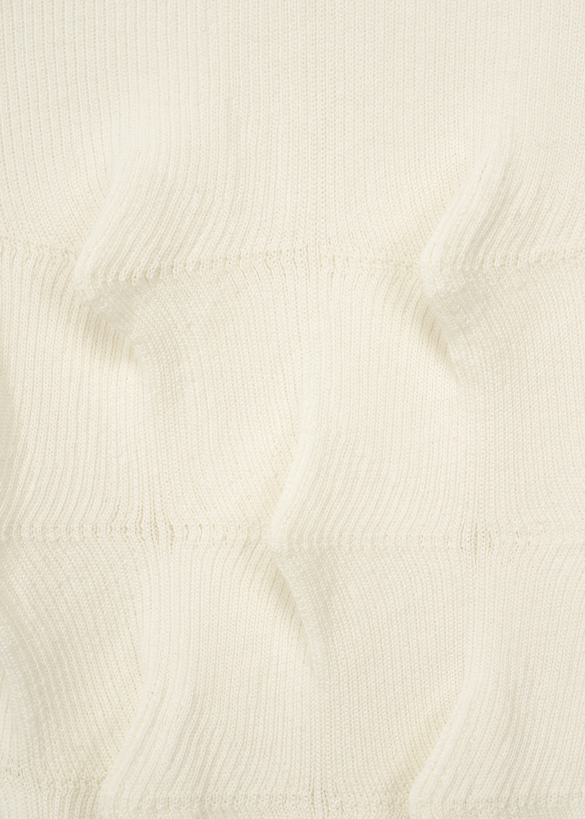 Zoomed view Close-up of the HaaT ZIG ZAG KNIT, a cream-colored organic cotton fabric featuring ribbed texture and raised, pointed sections in horizontal rows.
