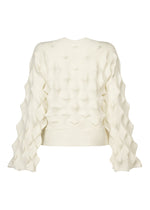 The HaaT ZIG ZAG KNIT is a cream-colored, long-sleeve organic cotton top with a textured, three-dimensional geometric pattern and raised diamond-shaped details on the back and sleeves.