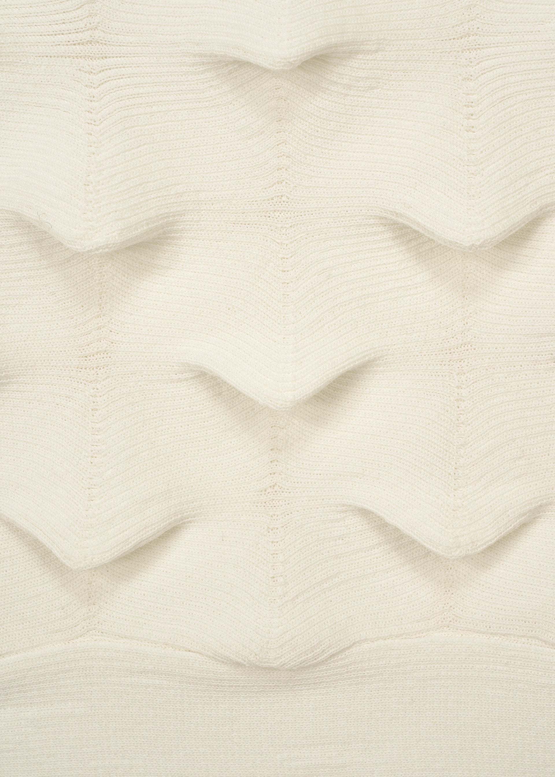 Zoomed view A close-up of HaaT’s ZIG ZAG KNIT fabric, made from organic cotton, showcases its off-white color and repeating raised zigzag pattern for a three-dimensional wavy texture.