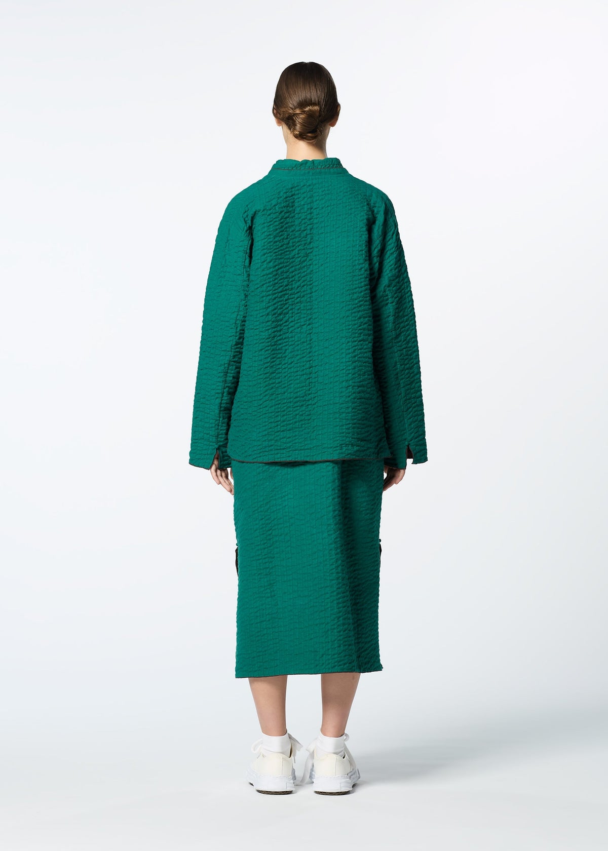 A person stands facing away from the camera, wearing HaaT's DUAL LAYER handwoven cotton jacket with Kabira embroidery and a matching skirt, paired with white sneakers—crafted by skilled Indian artisans against a plain white background. view 8 of 8