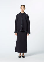 A woman faces forward in HaaT’s DUAL LAYER ensemble: a textured, loose-fit black shirt with light piping and subtle Indian embroidery, matching long skirt, and black flats. Her light brown hair is tied back; background is plain white.