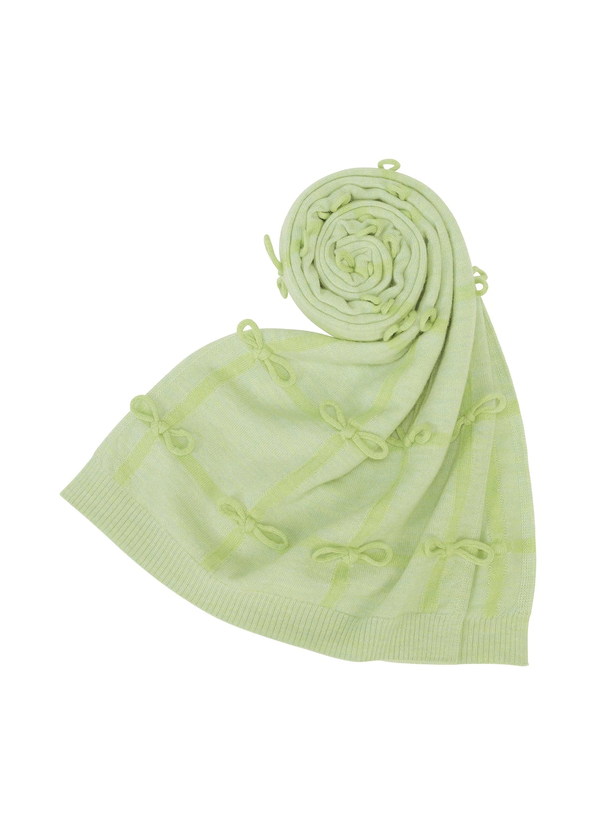 The HaaT RIBBON KNIT is a light green knitted blanket, featuring hand-tied decorative bow patterns and shown partially rolled up on a white background. view 3 of 7