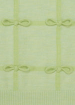 RIBBON KNIT by HaaT: A light green knit with a grid pattern and hand-tied bows at each intersection. The soft texture has a slightly ribbed bottom edge, echoing the look of a fulled wool stole.