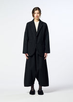 A person stands facing forward in the SAKIORI oversized dark plaid suit jacket and wide-leg pants by HaaT, paired with black shoes, against a plain white background.