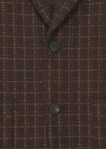 Close-up of the SAKIORI blazer by HaaT in brown textured grid-patterned fabric with two black buttons fastened, highlighting traditional weaving on the front torso and part of the collar.