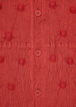 Close-up of HaaT’s KYO CHIJIMI SQUARE EMB fabric in textured red, featuring ruched patterns, round buttons at the center, and evenly spaced tufted circular details, all accented by subtle square embroidery inspired by traditional KYO CHIJIMI craftsmanship.