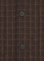 Close-up of SAKIORI by HaaT: brown textured fabric with a checkered pattern and two black buttons sewn vertically, inspired by traditional Sakiori weaving techniques.