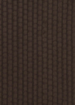 Close-up of SAKIORI by HaaT: dark brown woven fabric with a textured, grid-like pattern. Lighting accentuates the depth and traditional weaving-inspired structure.