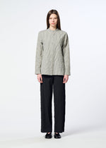 A person stands facing forward wearing the HaaT RIPPLE STRIPE light gray textured long-sleeve top, loose black seersucker pants, and black shoes against a plain light background.