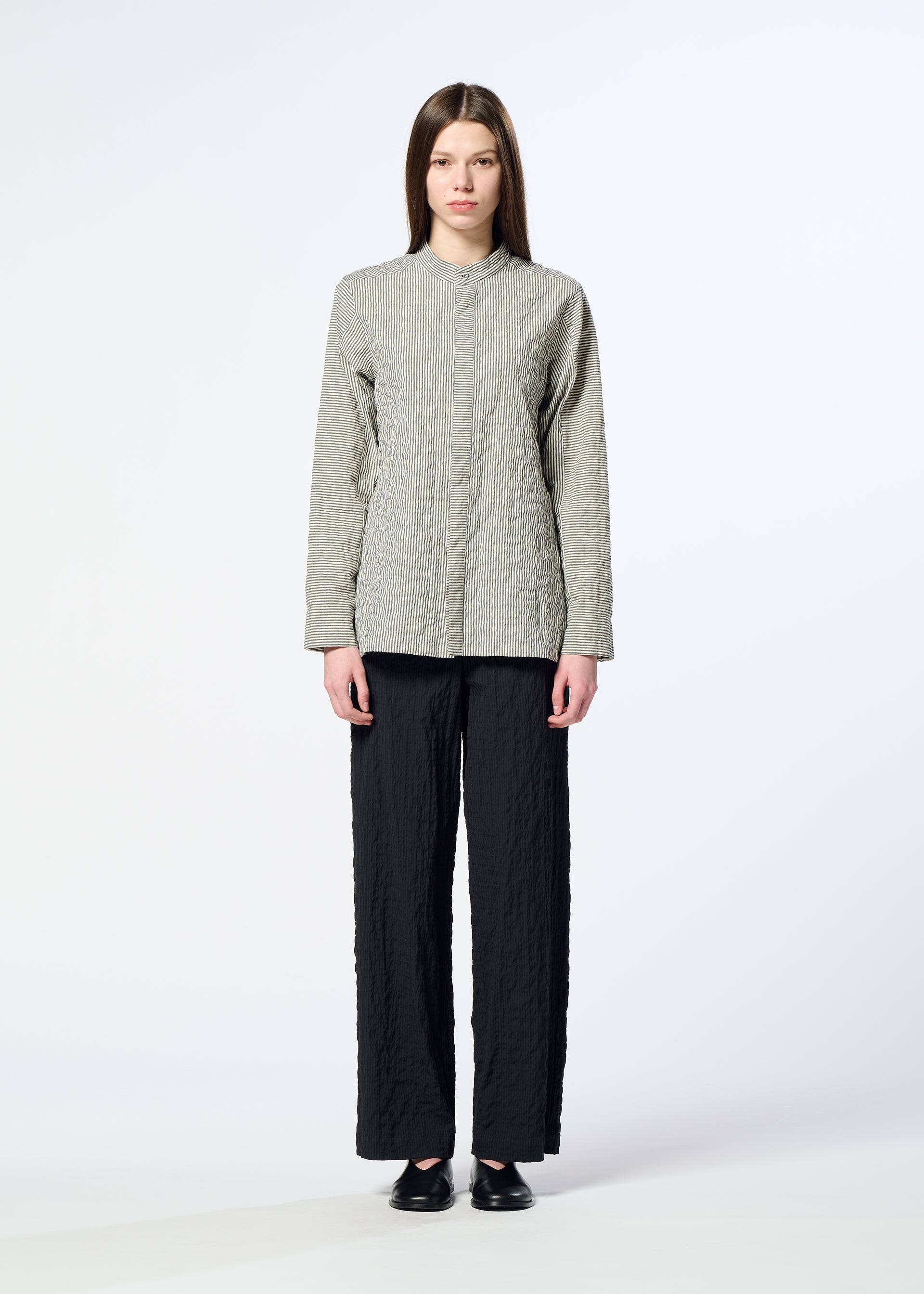 Zoomed view A person stands facing forward wearing the HaaT RIPPLE STRIPE light gray textured long-sleeve top, loose black seersucker pants, and black shoes against a plain light background.