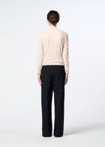 A woman stands with her back to the camera, wearing a textured light pink long-sleeve top and HaaT FLANNEL BOTTOM pants against a plain white background.
