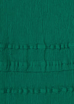 Close-up of green textured KYO CHIJIMI TSUCHIKABE fabric by HaaT, with vertical crinkles and two horizontal bands of small, evenly spaced raised bumps. Made from ultra-fine cotton for a crepe-like feel, reminiscent of KYO CHIJIMI pants.
