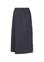 The HaaT HOLE & LINE skirt is a knee-length black twill piece featuring a textured, grid-like pattern, an asymmetrical wrap design, and subtle side tie detailing, shown against a plain white background. - NAVY （no.75）
