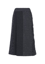 The COLLAGE STRETCH Ⅰ by HaaT is a black A-line midi skirt showcasing a patchwork pattern with subtle dotted embellishments, featuring varied textures and vertical paneling that evoke the timeless elegance of classic jacquard skirts.