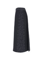 Side view of the HaaT COLLAGE STRETCH Ⅰ skirt, a long, high-waisted jacquard design with a subtle patterned texture and small white dots throughout; features a waistband and button detail.