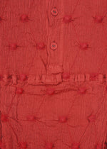 Close-up of textured red fabric featuring small, raised circular patterns, a horizontal stitched seam, and two red buttons on a button placket—evocative of the KYO CHIJIMI SQUARE EMB by HaaT with its signature crinkled texture.