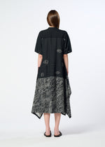 A woman with straight brown hair faces away, wearing the HaaT ONE STROKE DRAW jacquard dress with abstract white patterns, loose short sleeves, and a mid-calf length, styled simply with black sandals.