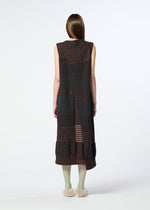 A person with long brown hair, seen from behind against a plain white background, is wearing the HaaT COLLAGE STRETCH Ⅰ— a sleeveless dark brown midi dress with jacquard-textured patterns—paired with light green tights and fluffy slippers.