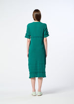 A woman with straight brown hair, seen from behind, wears a teal KYO CHIJIMI TSUCHIKABE dress by HaaT with textured horizontal details and light-colored flats, standing against a plain white background.