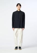 A person stands facing forward, wearing the HaaT RIPPLE STRIPE black long-sleeved unisex shirt, paired with loose white pants and black shoes against a plain light background.
