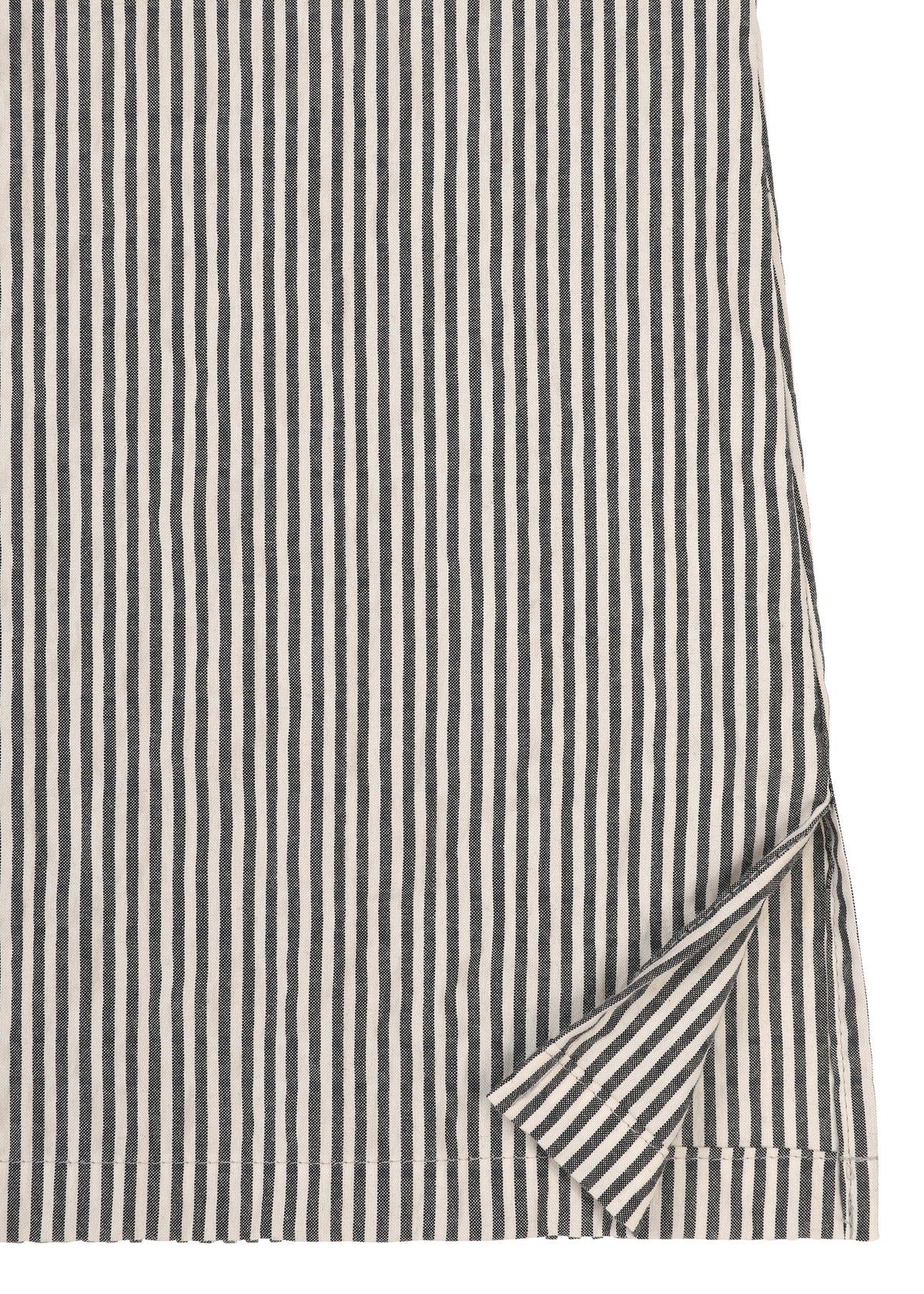 A close-up of HaaT’s RIPPLE STRIPE fabric from a long-sleeved shirt, featuring bold black and white vertical stripes; one corner is slightly folded to reveal that the reverse side displays the same stripe pattern. view 4 of 11