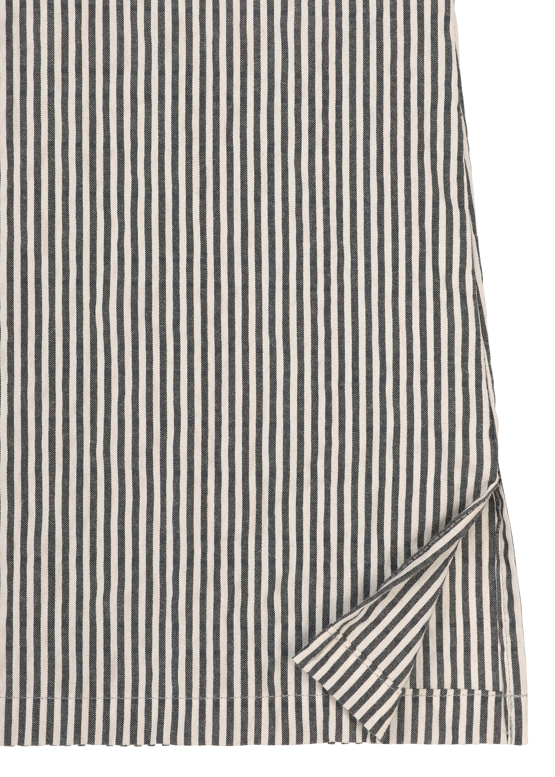 Zoomed view A close-up of HaaT’s RIPPLE STRIPE fabric from a long-sleeved shirt, featuring bold black and white vertical stripes; one corner is slightly folded to reveal that the reverse side displays the same stripe pattern.