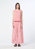 A woman with straight brown hair wears HaaT's ONE STROKE DRAW jacquard sleeveless top and matching wide-leg pants in a cotton-cupra blend, featuring subtle three-dimensional patterns. She pairs them with black sandals against a white background.