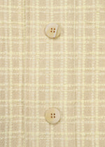 Close-up of SAKIORI by HaaT: light yellow woven fabric with a checkered texture, made with traditional techniques, featuring two beige buttons vertically aligned at the center.