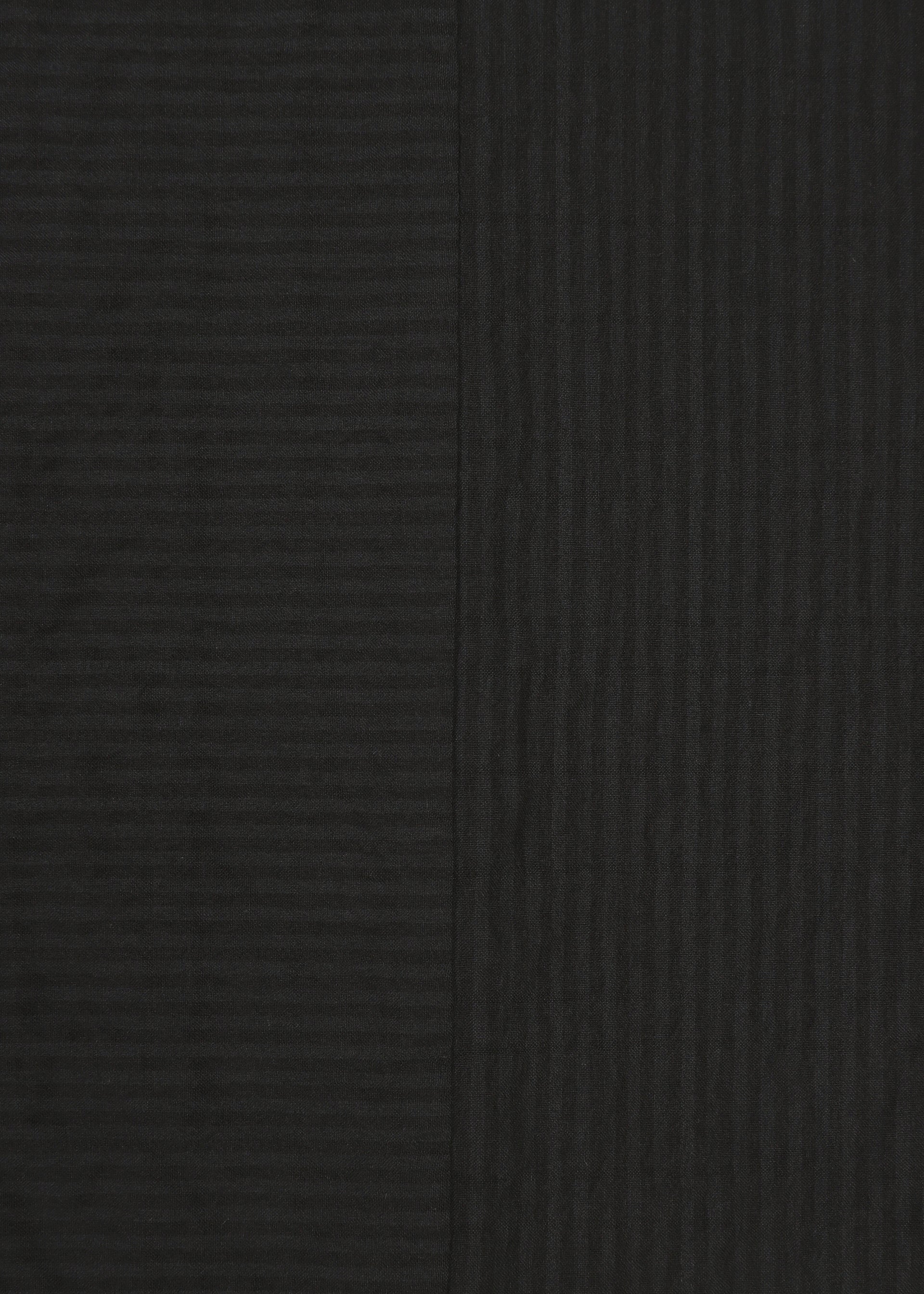 Zoomed view Two dark panels of HaaT’s RIPPLE STRIPE fabric are displayed side by side. Featuring a sophisticated wave-striped pattern, the left panel appears slightly lighter while the right panel is a deeper black; both showcase subtle texture and vertical lines.