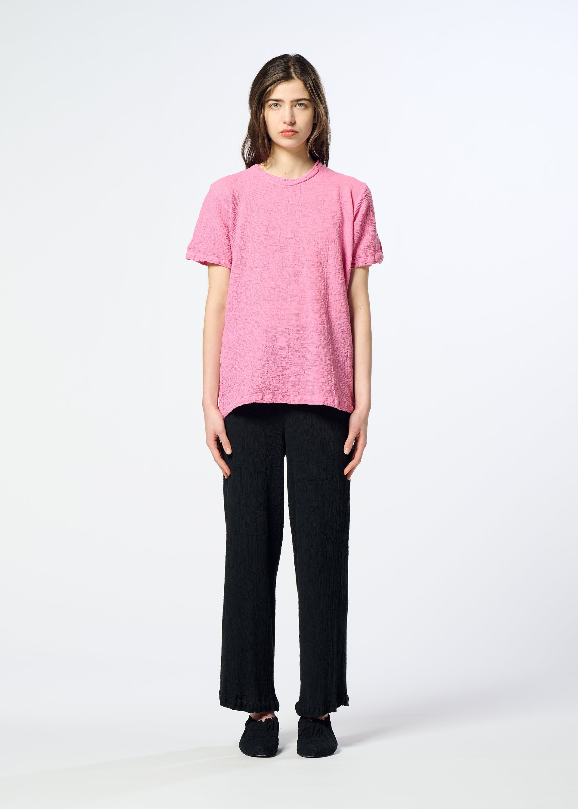 Zoomed view A person stands facing forward, wearing a loose pink HaaT KYO CHIJIMI 2WAY tunic with short sleeves, black pants, and black shoes, against a plain white background.