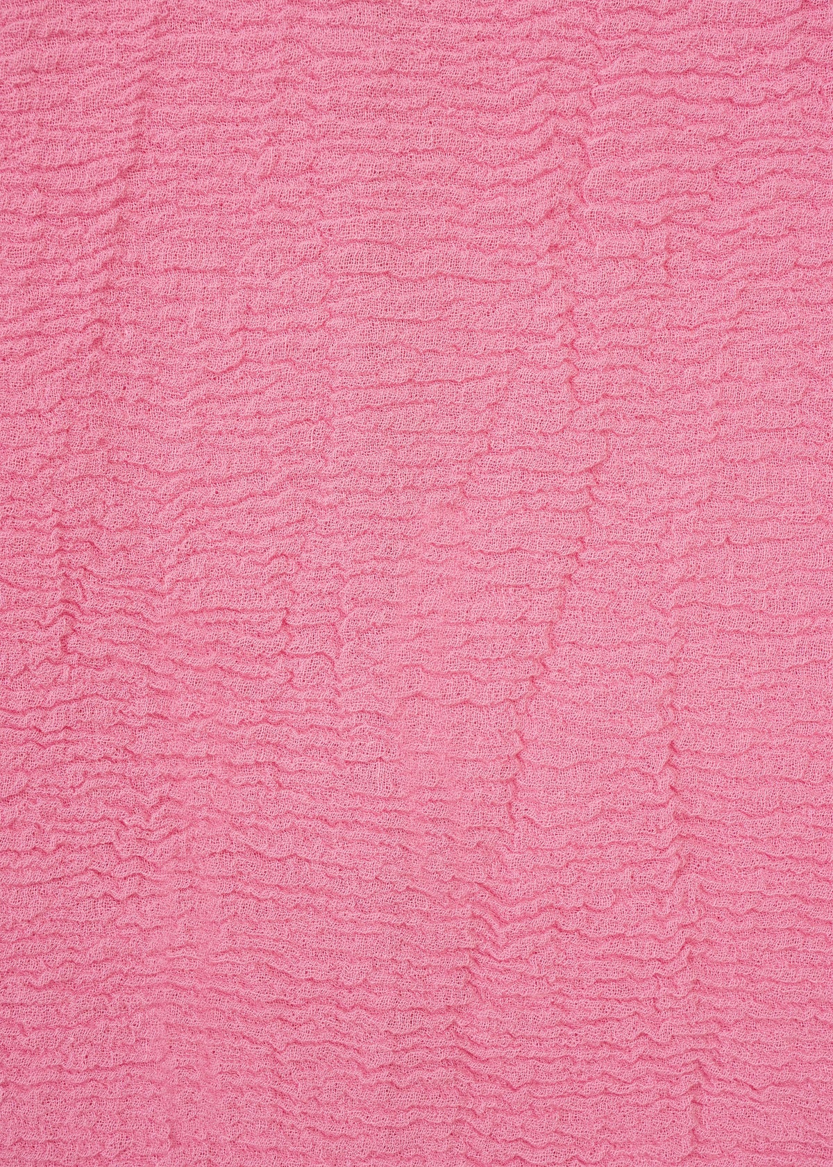 Textured pink fabric from HaaT’s KYO CHIJIMI 2WAY collection, featuring horizontal rippled lines that form a wavy pattern across the surface. Inspired by traditional KYO CHIJIMI tunic textiles, the material has a soft, tactile look and displays consistent color throughout. view 5 of 8