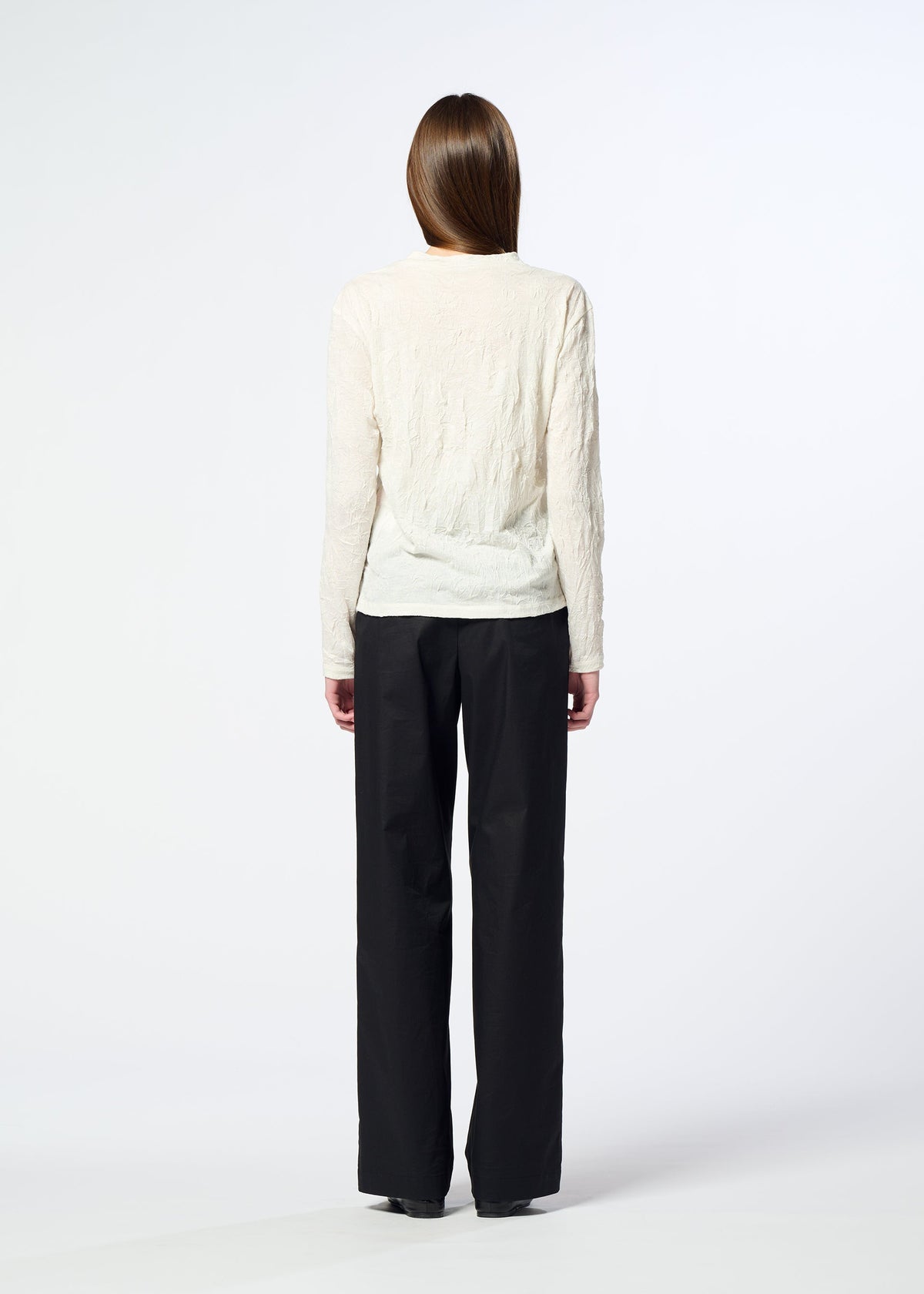 A person stands facing away from the camera, wearing the HaaT W/P WASHER round-neck long-sleeved top in cream and loose black trousers against a plain white background. view 8 of 8