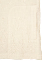 A close-up of HaaT’s W/P WASHER fabric showcases its soft, crumpled white wool jersey texture with visible creases and intricate stitching, evoking the cozy feel of a premium long-sleeved top.
