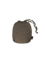 The HaaT KUMO SHIBORI is an olive-green crinkled drawstring bag with two string ties and a small black and red tag on the side, shown against a white background.