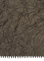 Crinkled brown KUMO SHIBORI fabric by HaaT features an uneven, textured surface and a row of small tassels or fringe along the bottom edge, inspired by traditional Shibori techniques.