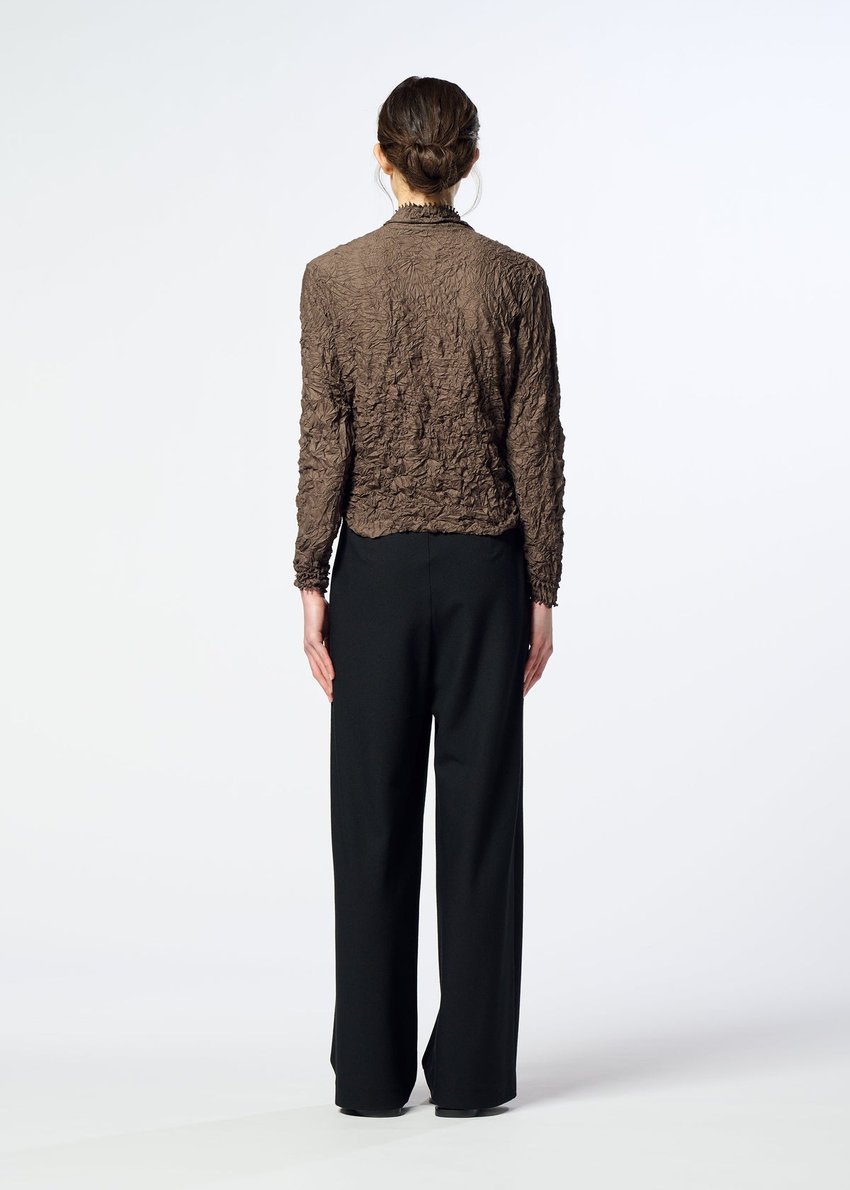 A person with brown hair in an updo wears the KUMO SHIBORI high-neck cardigan from HaaT and loose black pants, standing facing away against a plain white background. view 10 of 11