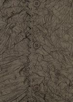 Close-up of crinkled brown fabric with four brown buttons and decorative stitching, evoking KUMO SHIBORI by HaaT on a high-neck cardigan.