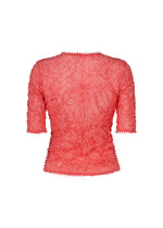 The HaaT KUMO SHIBORI KNIT SHEER is a semi-sheer coral pink top with a fitted silhouette, elbow-length sleeves, crinkled texture, zigzagged edges, and a ruched look, shown from the back against a white background.